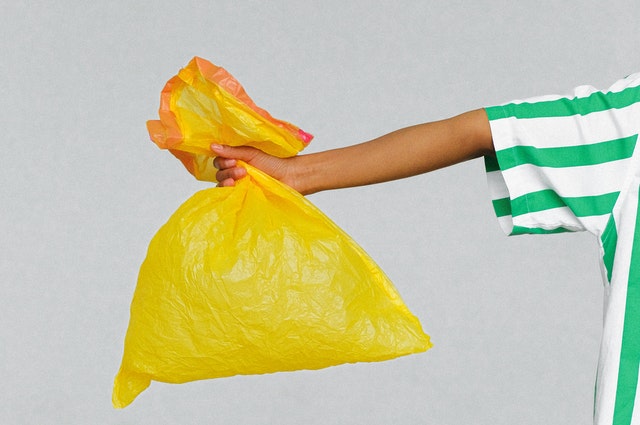 Zdjęcie przedstawiające rękę trzymającą worek na śmieci